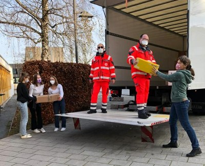 Frau Bierprigl übergibt ein Paket an die Helfer der Johanniter